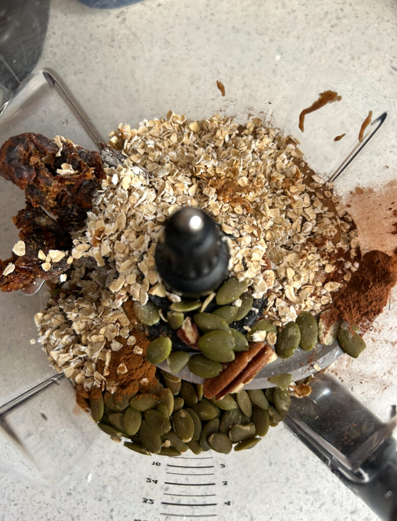 bliss ball ingredients in a food processor before they are blended