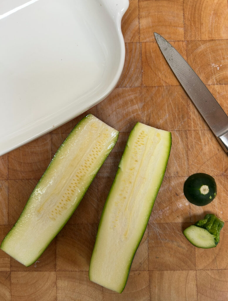 Slice zucchini in half and lengthwise before hollowing the insides out